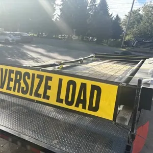 M&M trailer with an oversize-load banner for commercial delivery