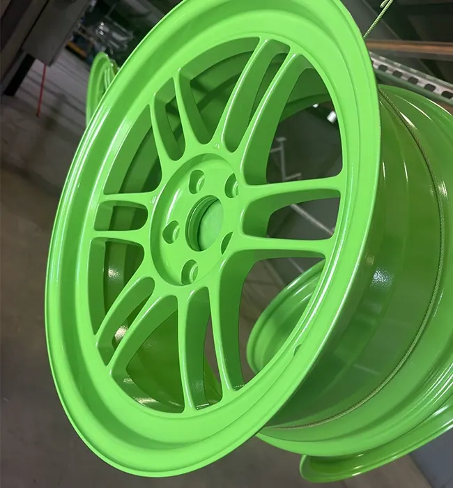 Wheel powder coated in bright lime green, hanging after cure